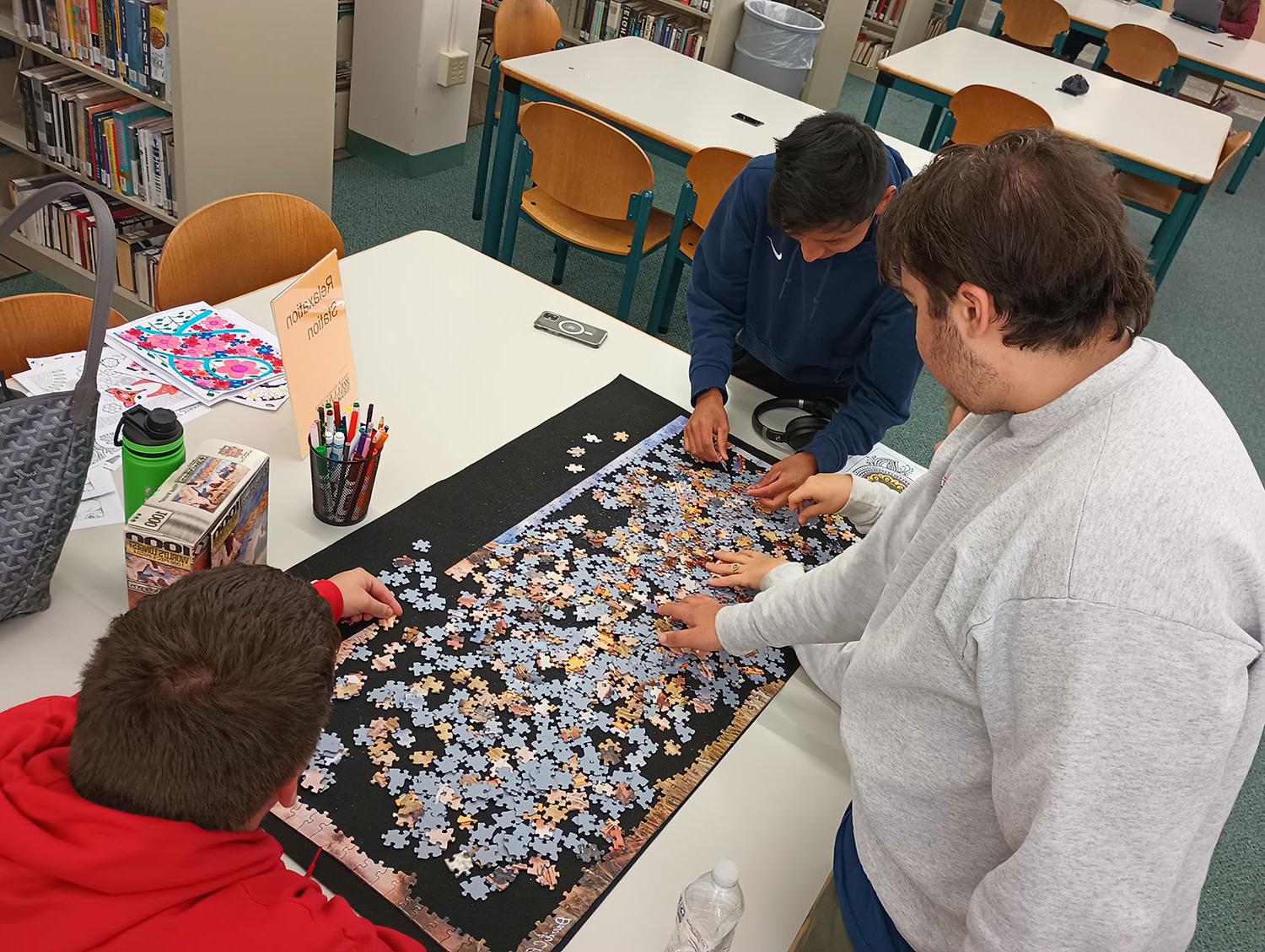 students completing puzzle at library relaxation station