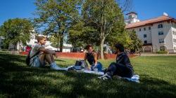 Students sitting on a blanket on the lawn at Montclair State University.